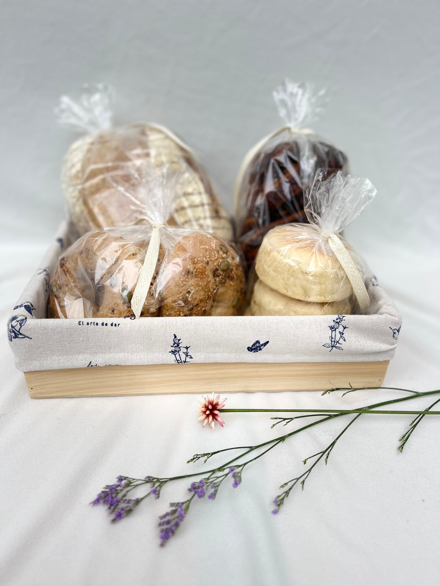 Caja de madera con panes artesanales: masa madre, bagels, pan trenza brownie y english muffins